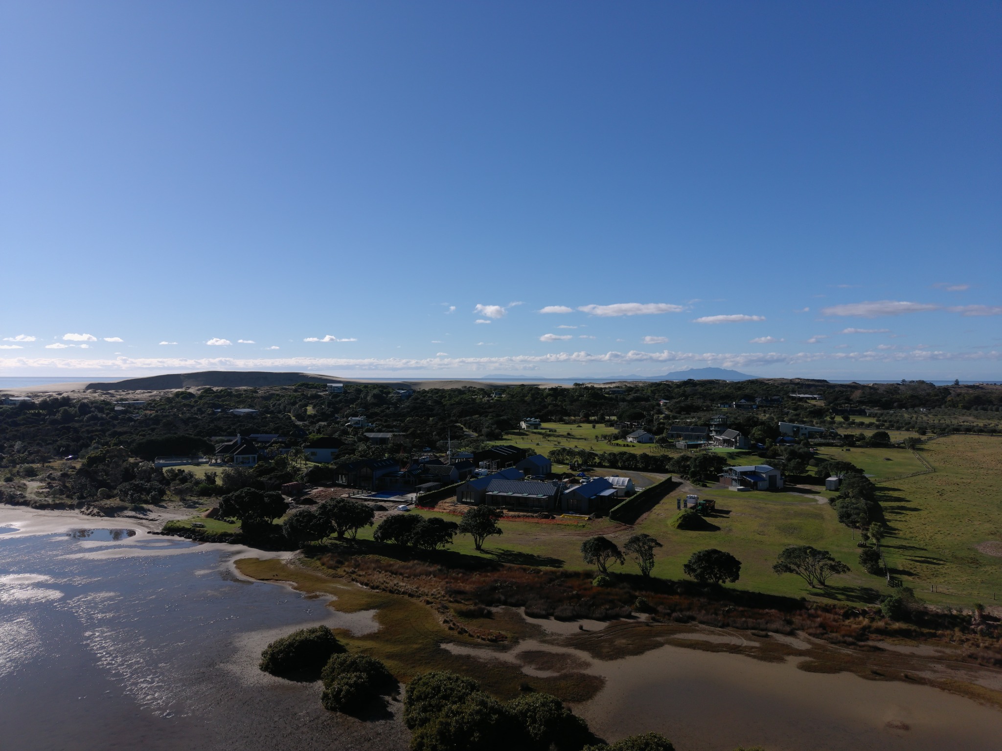 Wide aerial view placing Tern Point within the Mangawhai Harbour and coastal landscape